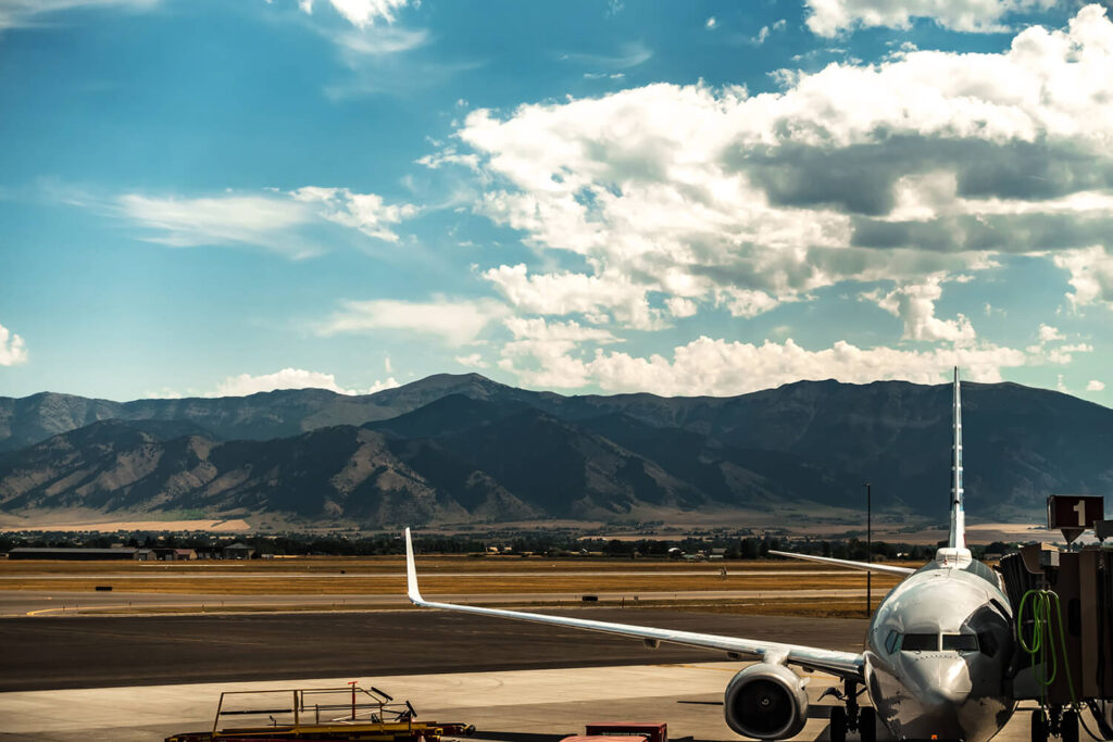 Airplane on Bozeman Airport tarmac with mountains in the background